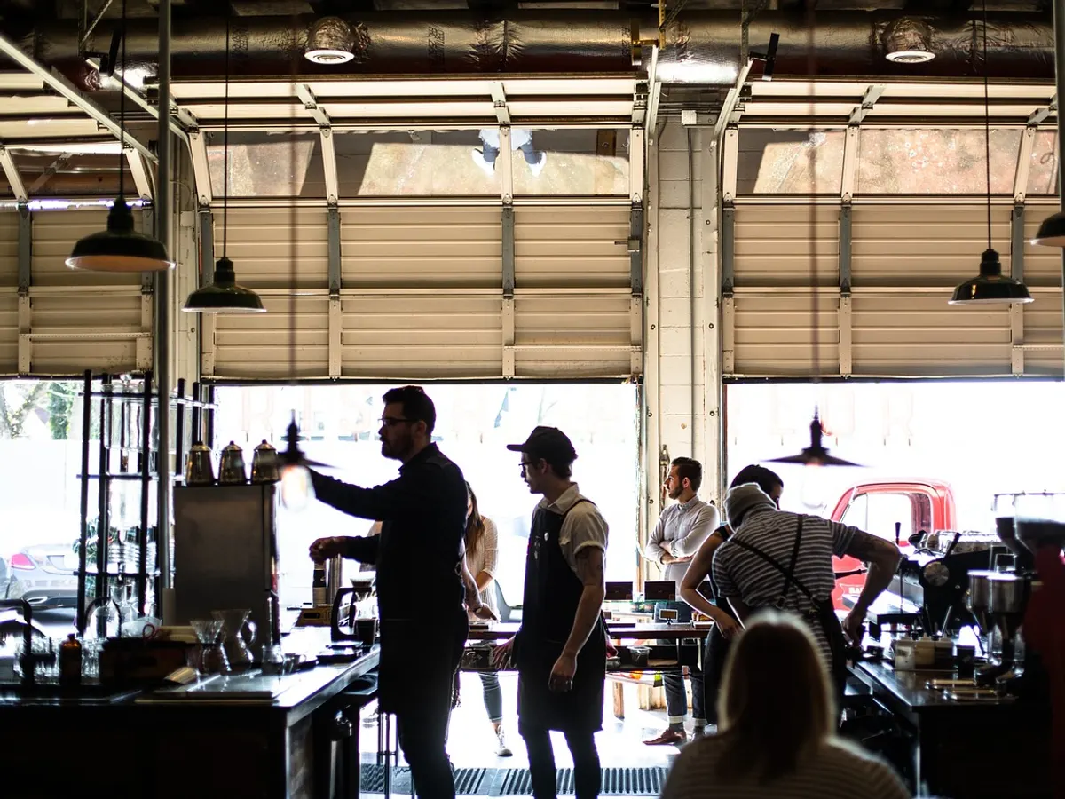 A small business team at work behind the counter of a busy coffee shop