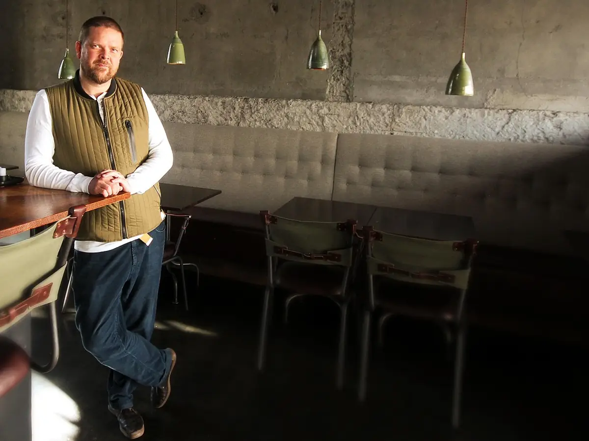 A restaurant owner standing in his dining room